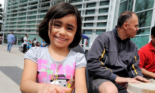 People sitting outside, child in the forefront 