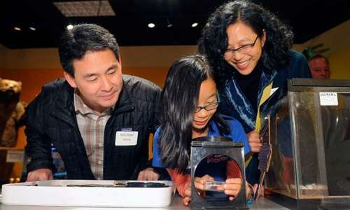 A family looks at a specimen