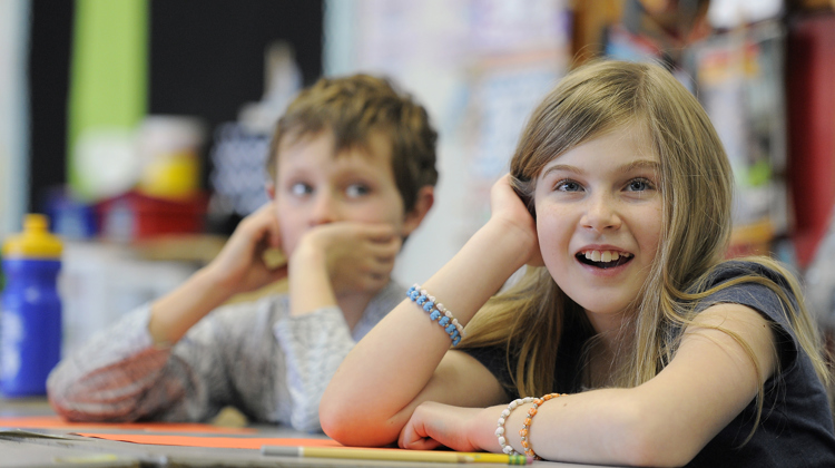 Two students engage with a virtual program from their classroom.