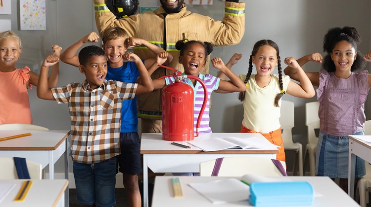 A group of students flexing their biceps and smiling